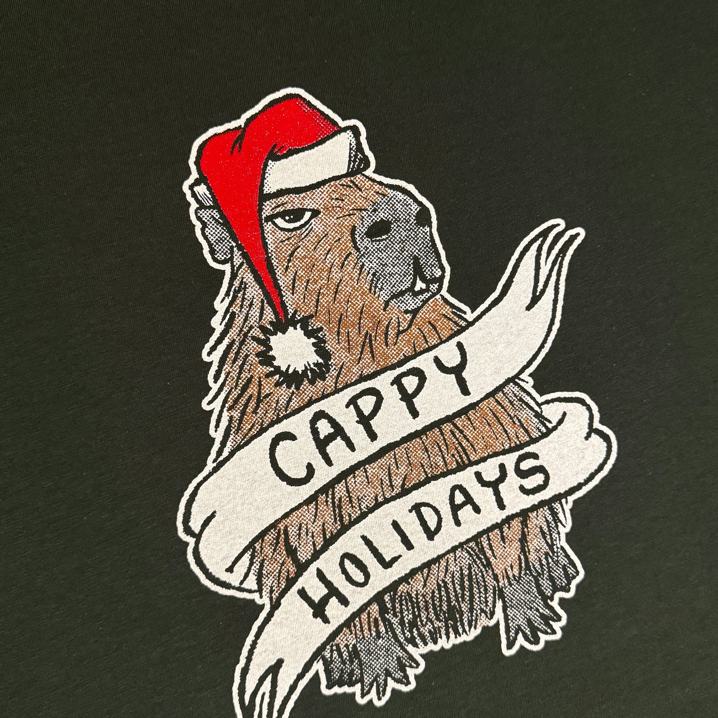 Dark green t-shirt with a graphic of a capybara wearing a Santa hat and a banner reading 'Cappy Holidays'.