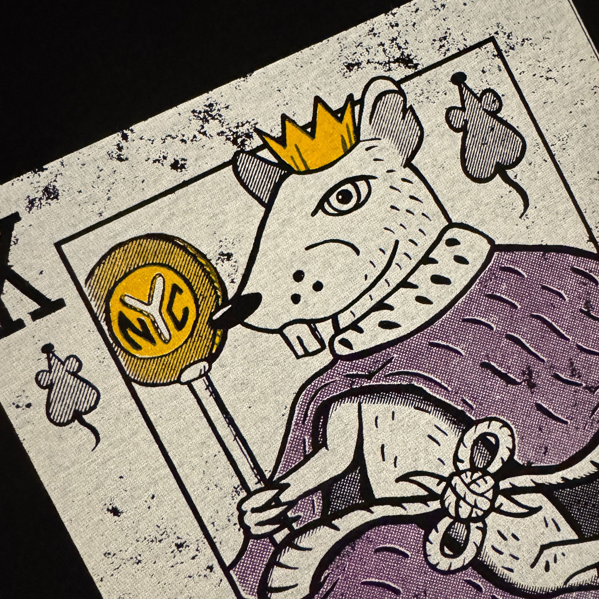 Close-up of a playing card with a rat king design on a dark background