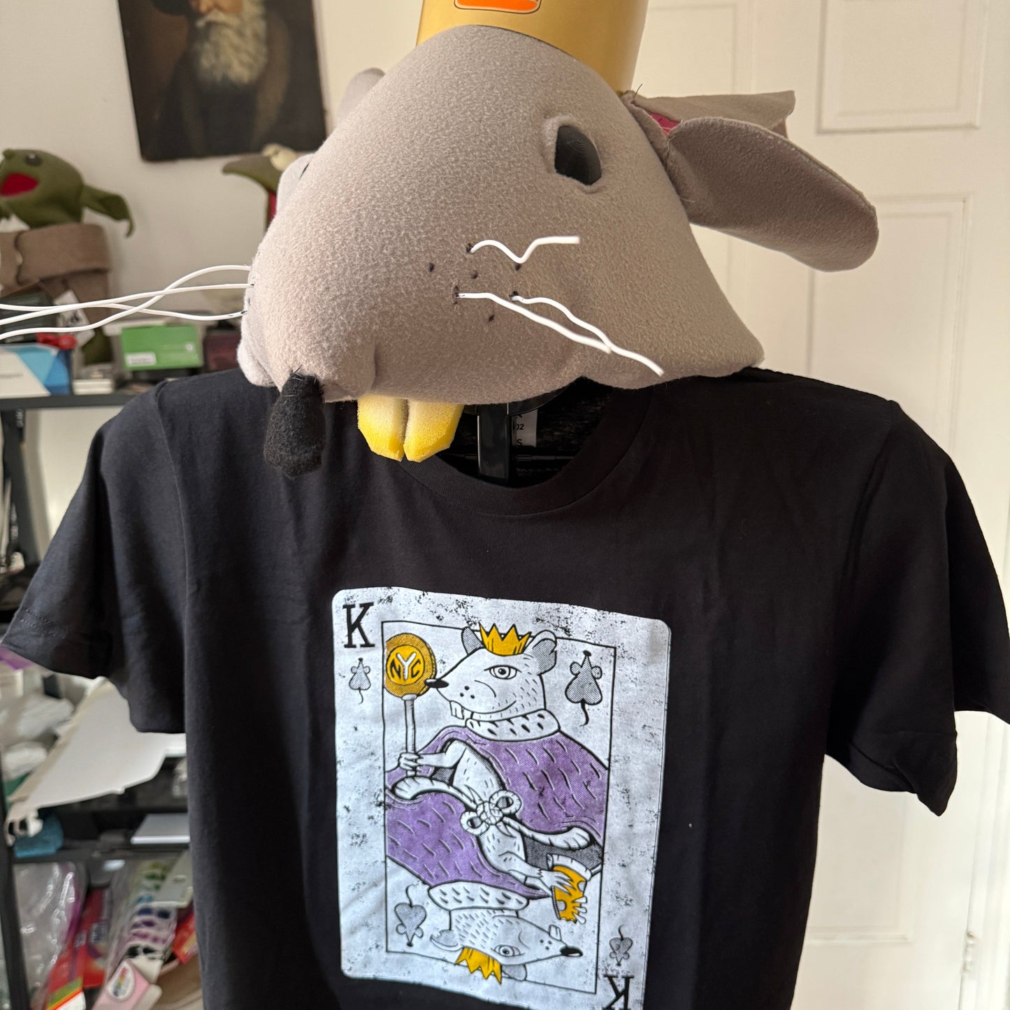 Black t-shirt with a graphic design on the chest of a rat king playing card.