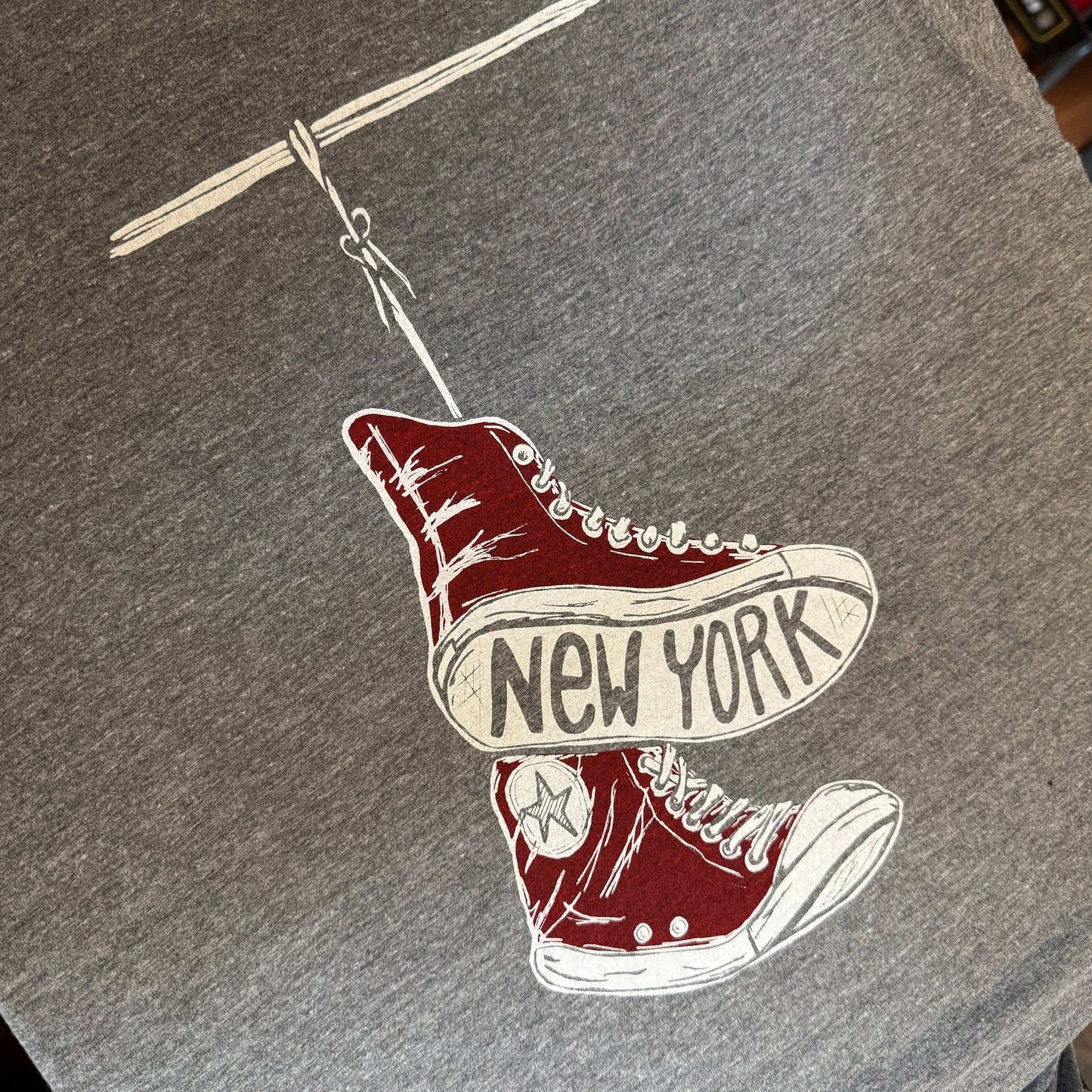Gray t-shirt with red and white sneakers graphic and 'New York' text on the sole