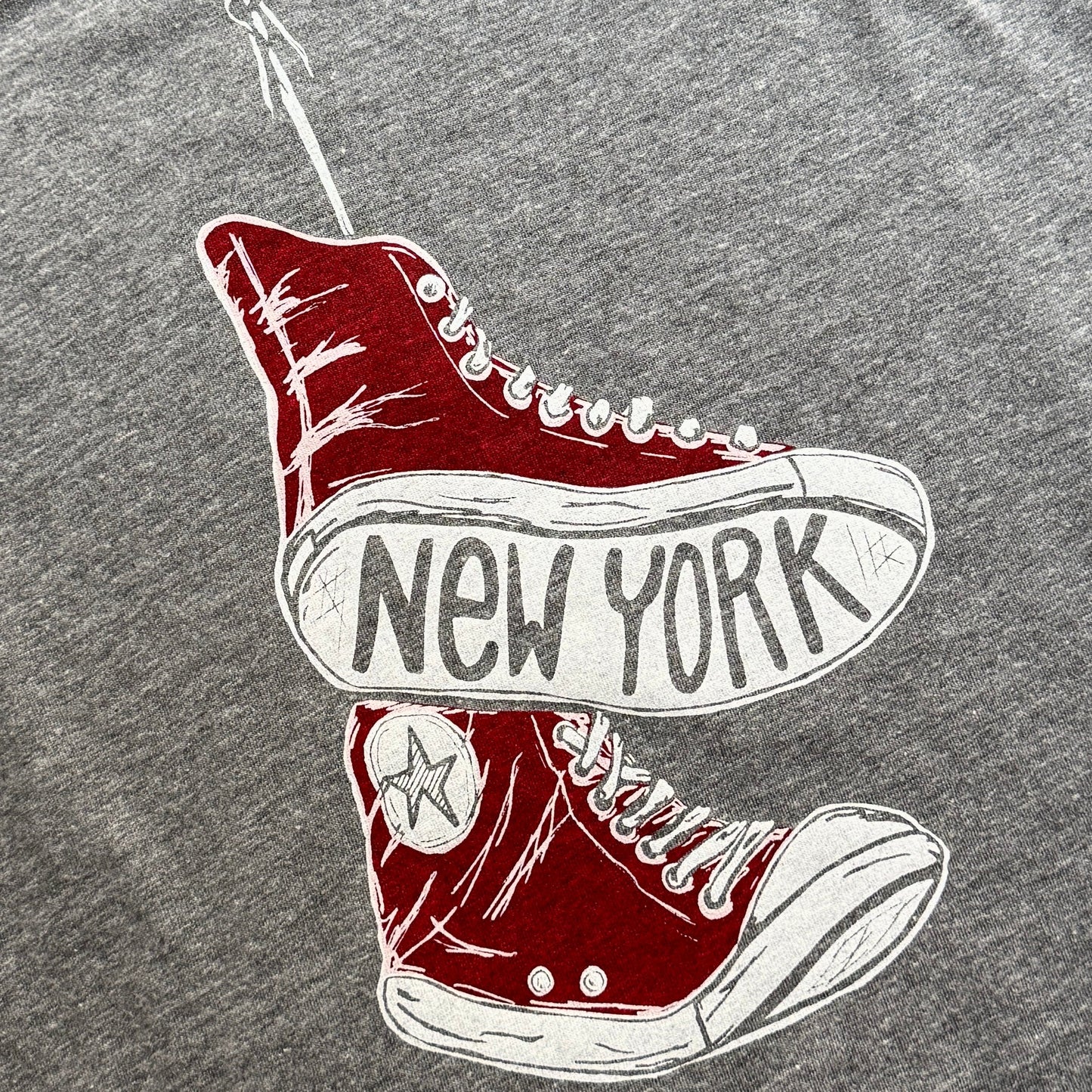 Red high-top sneakers with 'New York' text on a gray background