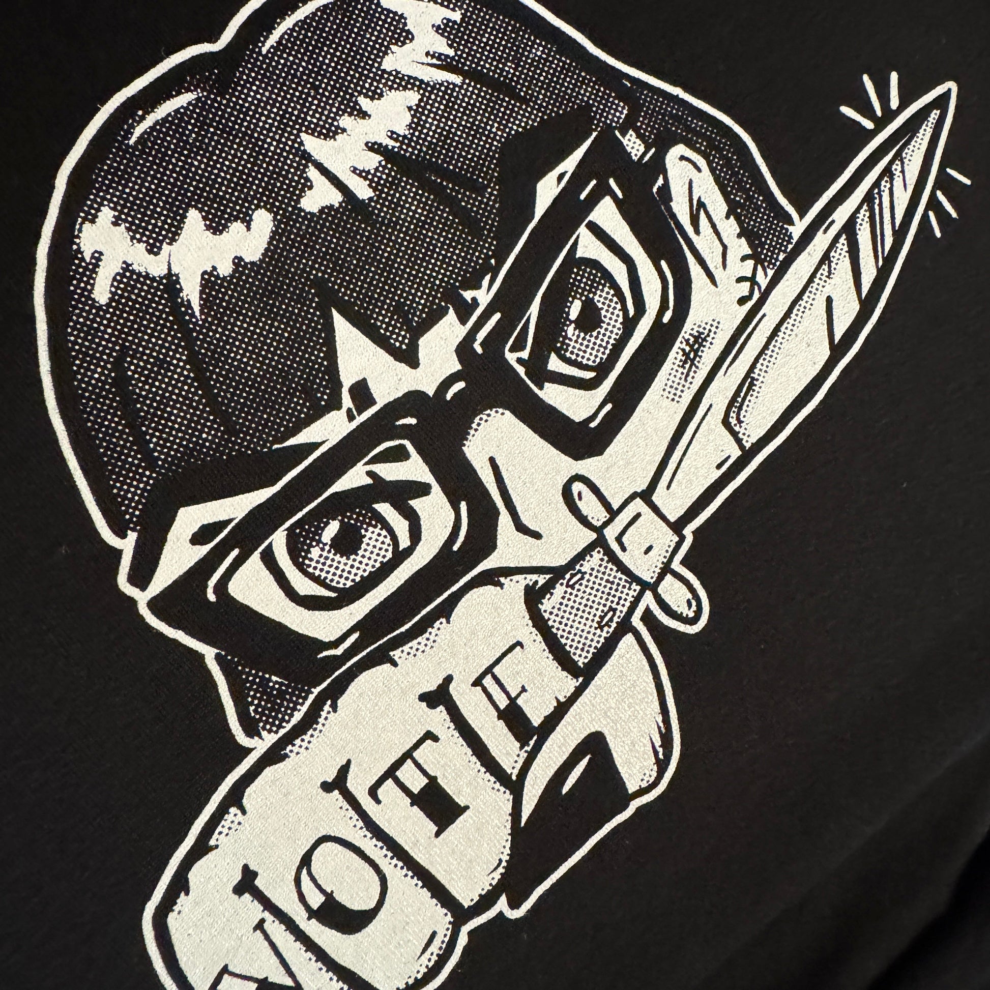 Black t-shirt with white graphic design of a girl with glasses holding a knife and text on a black background
