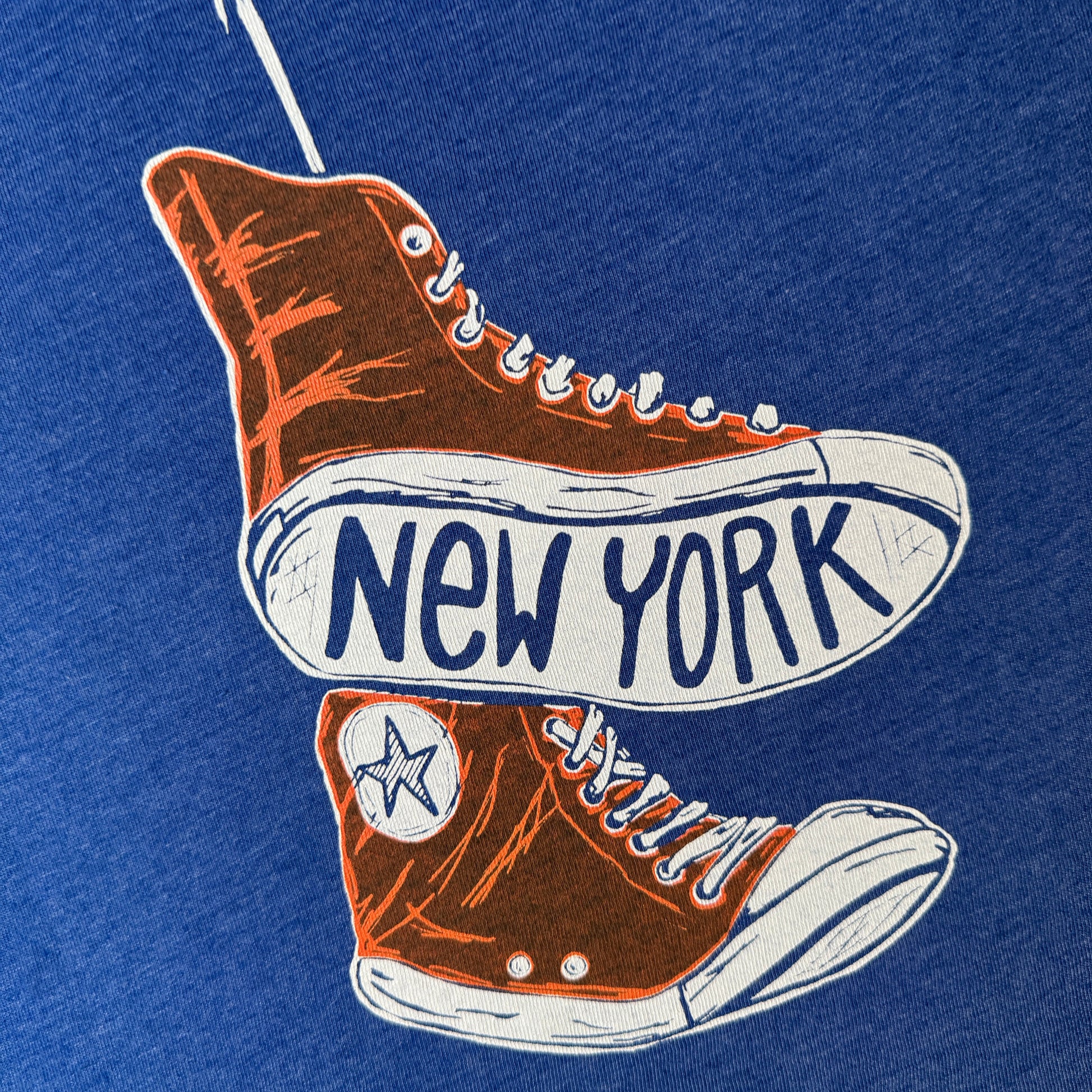 Illustration of a orange NY KNICKS converse sneakers with 'New York' text on the sole on a blue t-shirt
