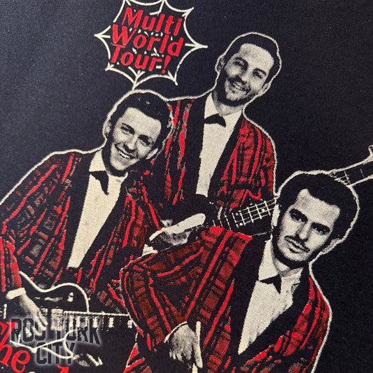 Image of the 3 Spider-Man actors put together as a rock band in red plaid suits with guitars, featuring text 'Multi World Tour' hand printed on a dark t-shirt.